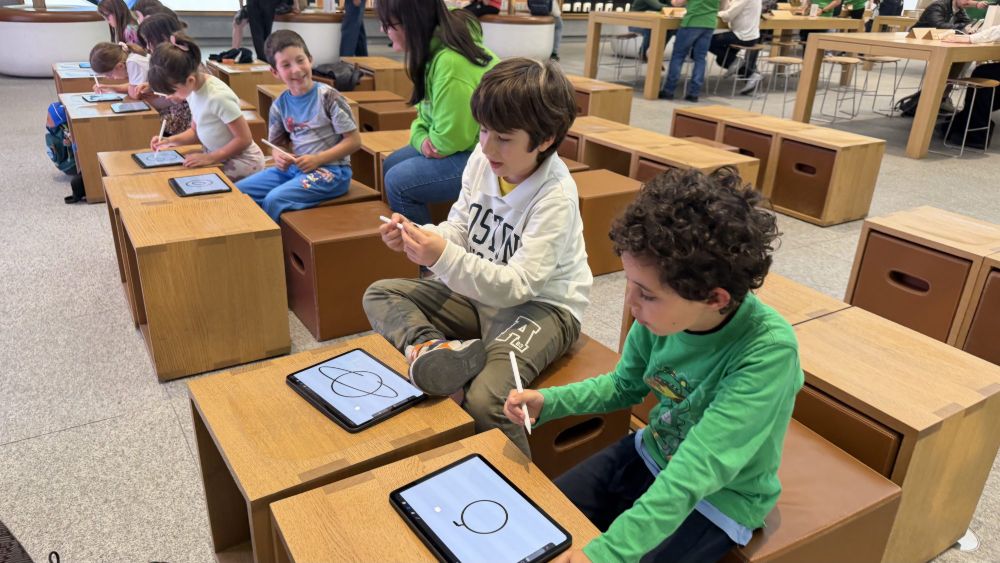 Bambine e bambini seduti nell’Apple Store disegnano su iPad con la matita digitale