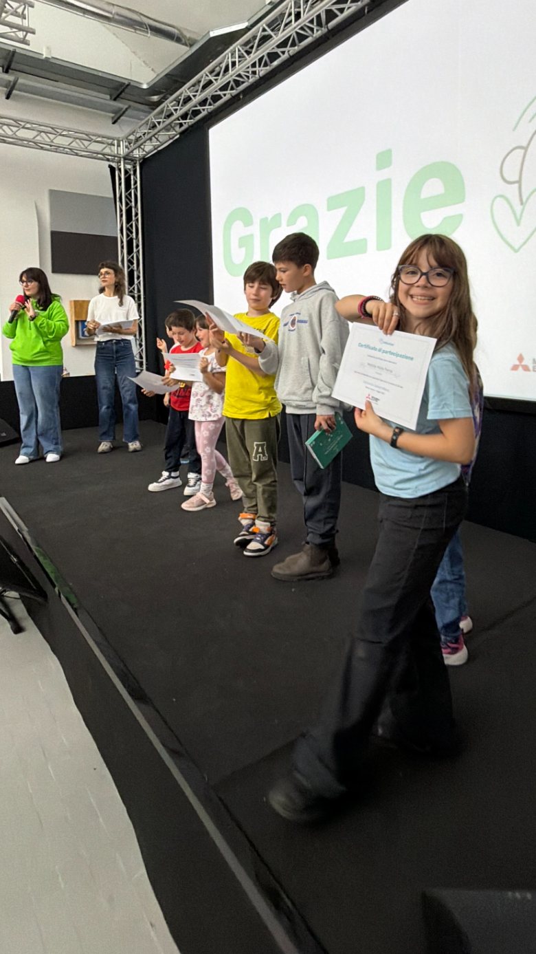 Bambine e bambini sul palco con i certificati di partecipazione al termine della prima edizione